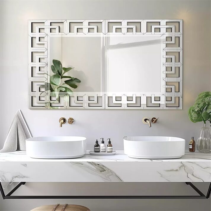 Verra Luxe Home Grecian Venetian wall mirror with a silver rectangular frame featuring a geometric Greek-key design, mounted above dual sinks in a modern bathroom