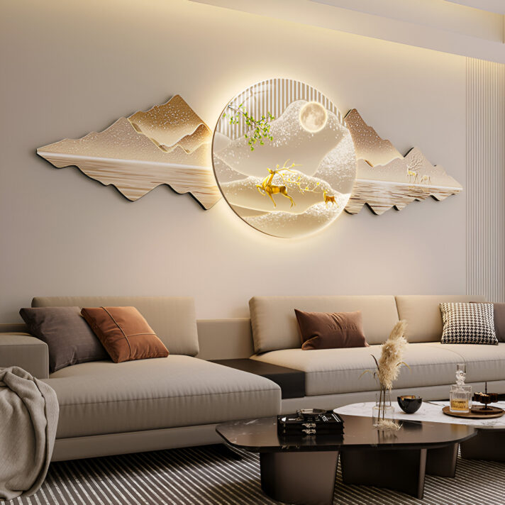 Nordic LED Wall Art with a round moonlit landscape featuring deer and mountains, a warm soft glow, displayed above a beige sectional in a modern living space.