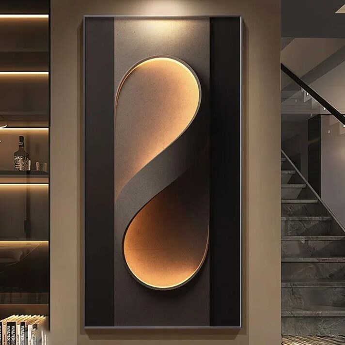 Verra Luxe Home wall light with a gold curved shade inside a dark rectangular frame, emitting a warm ambient glow for contemporary interiors