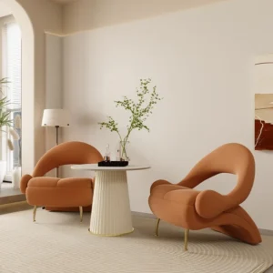 Verra Luxe Home Luxury Single Sofa Chair in soft peach flannel fabric with a curved ergonomic silhouette and gold legs, placed in a bright living space.