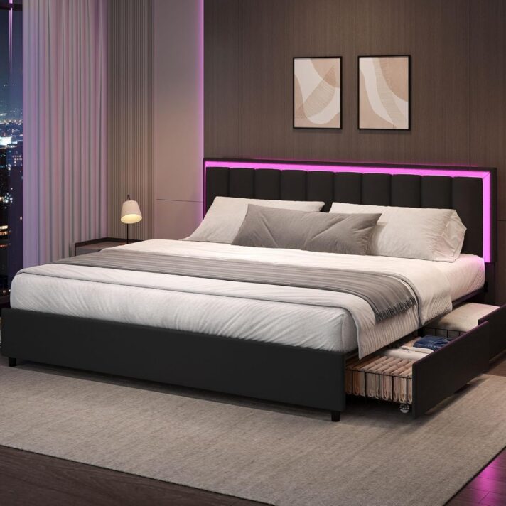 Verra Luxe Home stylish king bed frame with dark gray upholstery and pink LED lighting along the headboard, paired with white bedding and gray throw pillows against a city-view backdrop.