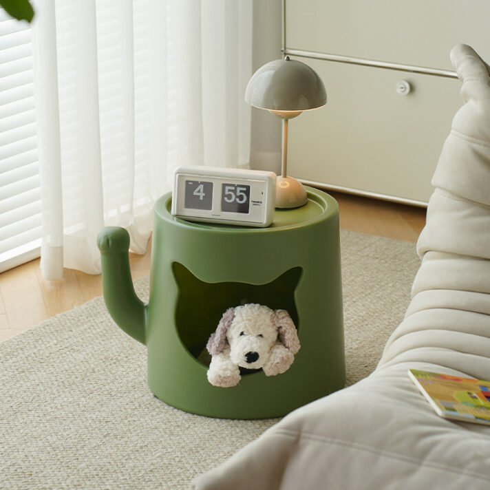 Green round cat-nest bedside coffee table by Verra Luxe Home, with a small clock and lamp on top and a plush dog visible through the cat-shaped cutout