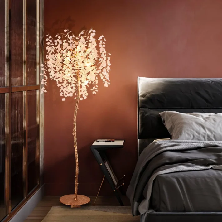 Luxury Crystal Tree Floor Lamp with copper finish and crystal branches, placed beside a dark bed in a warm brown bedroom, matching Verra Luxe Home’s modern decor aesthetic.