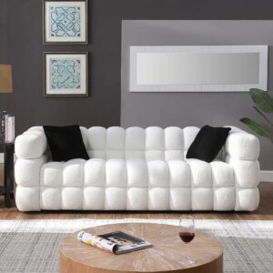 White Sherpa boucle deep-seat sofa with a cloud-like tufted design and two black accent pillows set against a modern living room backdrop, reflecting Verra Luxe Home styling.