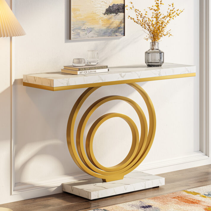 Modern Gold Console Table with white faux marble top and sculptural circular gold legs, shown with a vase, glassware, and a Dior book stack.