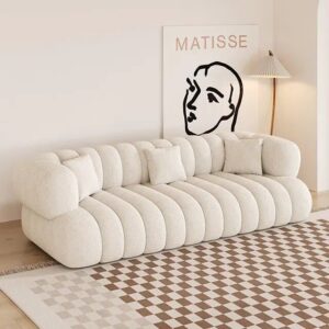 Cream off-white modular sofa with rounded, tufted cushions in a bright living room, paired with a Matisse line-art print on the wall.