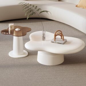 White cloud-shaped coffee table with a matching end table on a beige carpet, accented by a small vase with a branch and a stack of books, seen in a modern living room by Verra Luxe Home.