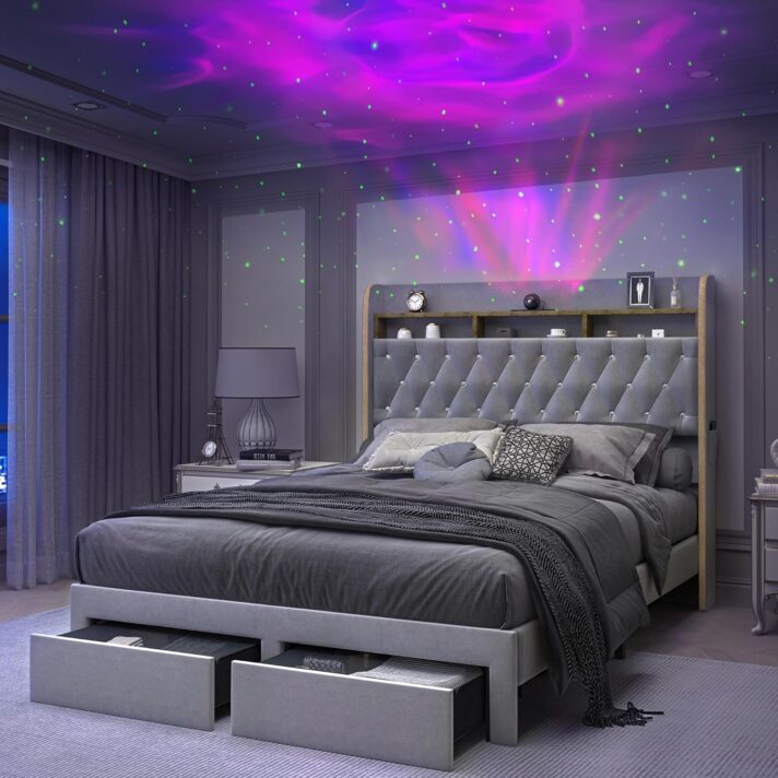 Verra Luxe Home Queen LED Bed Frame with Storage Drawers in gray velvet upholstery featuring a tufted headboard and galaxy lights projecting purple-green dots across the room