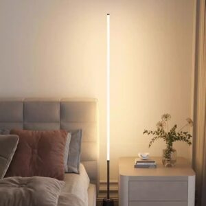 Modern Nordic LED Corner Floor Lamp with a slim vertical glow beside a contemporary bedroom, featuring a brushed nickel base and a warm ambient glow.