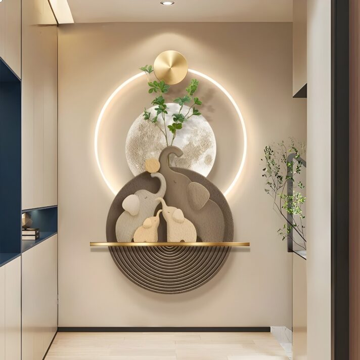 Luminous Elephant Sandstone LED Wall Art features abstract elephant forms in warm beige tones set against a circular glowing ring and a horizontal gold bar, with a moon-like texture in the background.