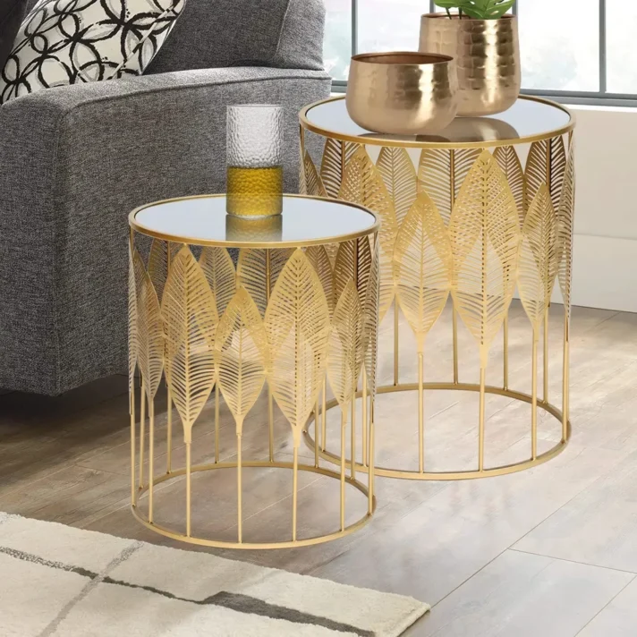 Gold metal nesting end tables by Verra Luxe Home with leaf-inspired pattern, round white-topped surfaces and mirrored gold frames
