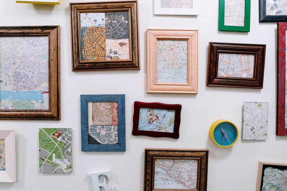 Colorful wall art featuring assorted framed maps and city layouts in brown, blue, and green frames; abstract map art arrangement for contemporary interiors